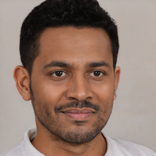 Joyful black young-adult male with short  brown hair and brown eyes