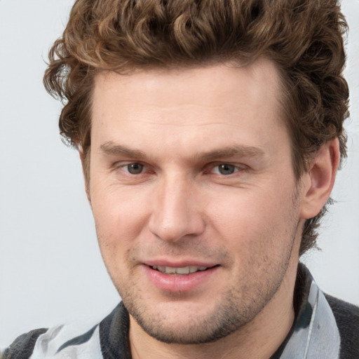 Joyful white adult male with short  brown hair and grey eyes