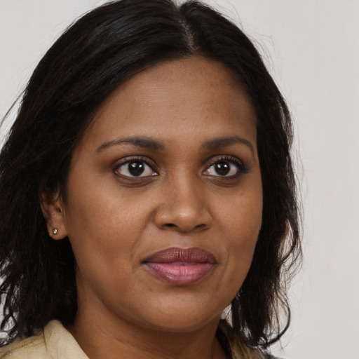 Joyful black young-adult female with long  brown hair and brown eyes