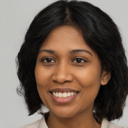 Joyful black young-adult female with medium  black hair and brown eyes