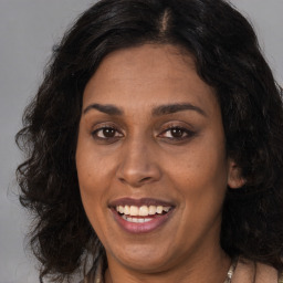 Joyful black adult female with long  brown hair and brown eyes