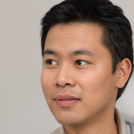 Joyful asian young-adult male with short  black hair and brown eyes