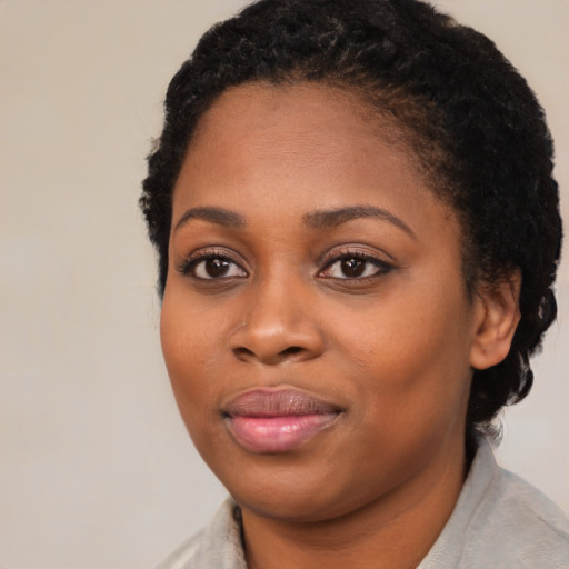 Joyful black young-adult female with medium  brown hair and brown eyes