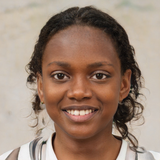 Joyful black child female with medium  brown hair and brown eyes
