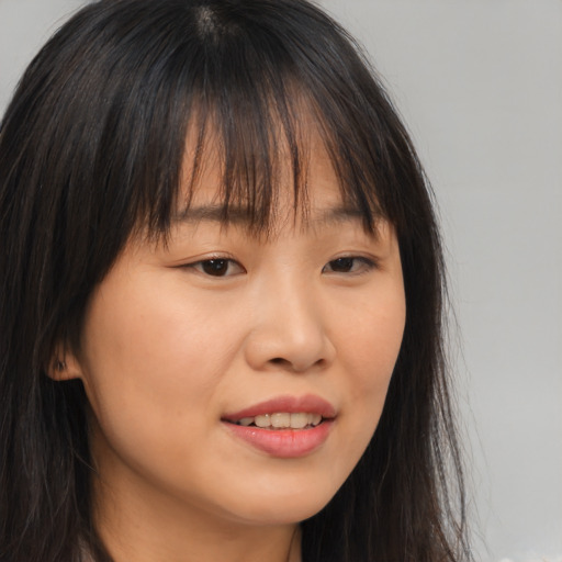 Joyful asian young-adult female with long  brown hair and brown eyes