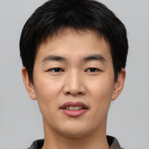 Joyful asian young-adult male with short  brown hair and brown eyes