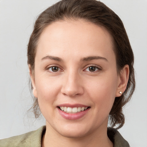 Joyful white young-adult female with medium  brown hair and grey eyes