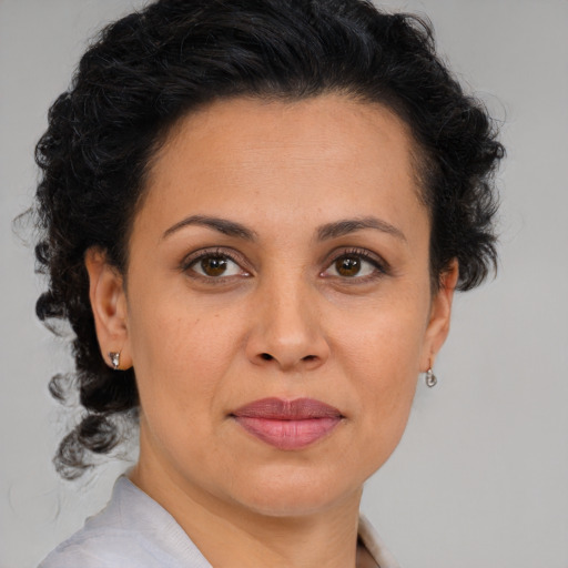 Joyful latino adult female with medium  brown hair and brown eyes