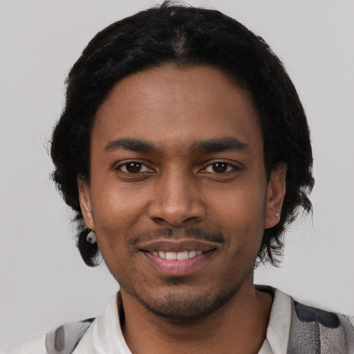 Joyful black young-adult male with short  black hair and brown eyes