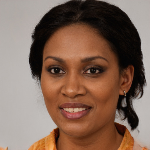 Joyful black adult female with medium  brown hair and brown eyes