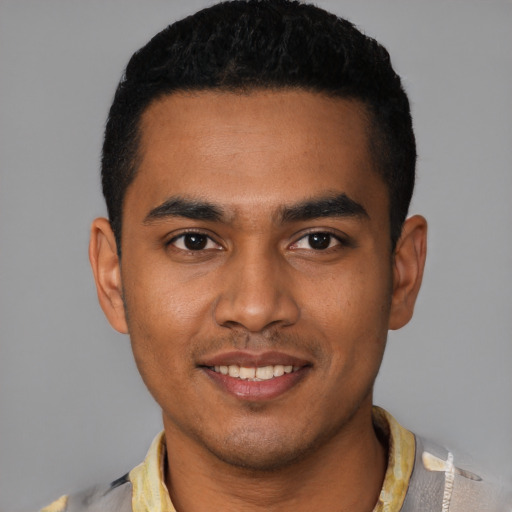Joyful black young-adult male with short  black hair and brown eyes