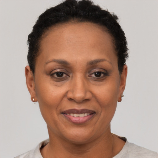 Joyful black adult female with short  black hair and brown eyes