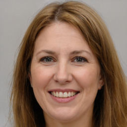 Joyful white adult female with long  brown hair and brown eyes