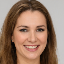 Joyful white young-adult female with long  brown hair and green eyes