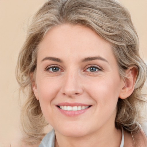 Joyful white young-adult female with medium  brown hair and blue eyes