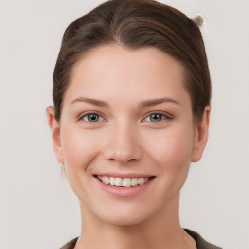 Joyful white young-adult female with short  brown hair and grey eyes