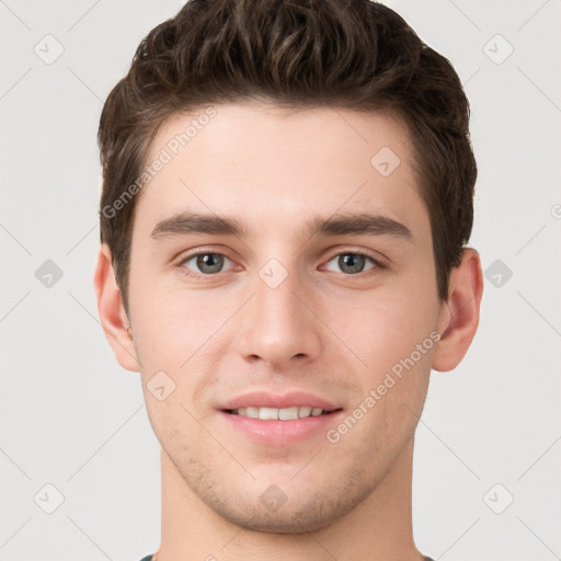 Joyful white young-adult male with short  brown hair and grey eyes