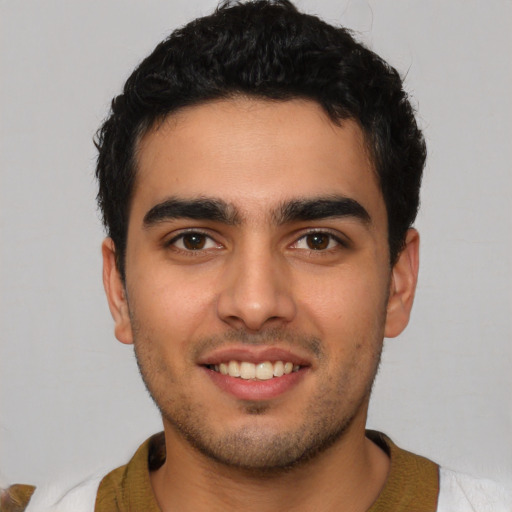 Joyful latino young-adult male with short  brown hair and brown eyes