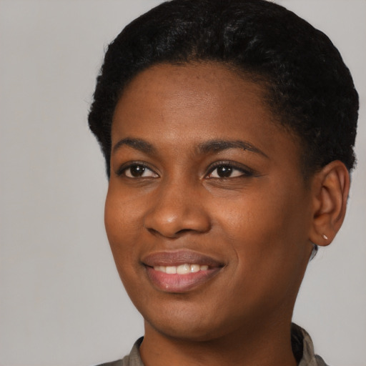 Joyful black young-adult female with short  black hair and brown eyes