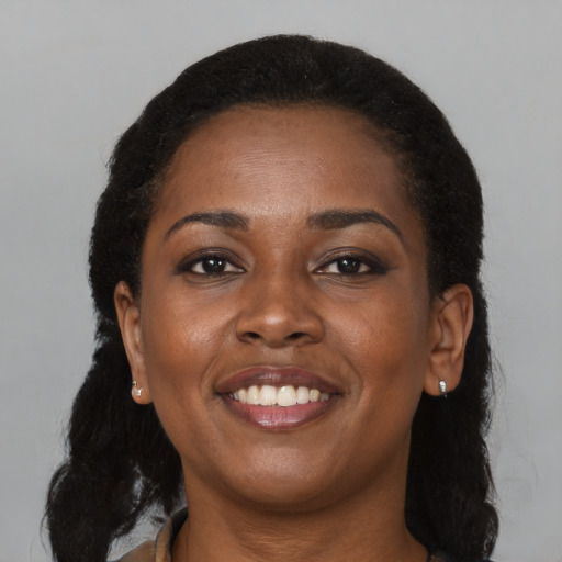 Joyful black young-adult female with long  black hair and brown eyes