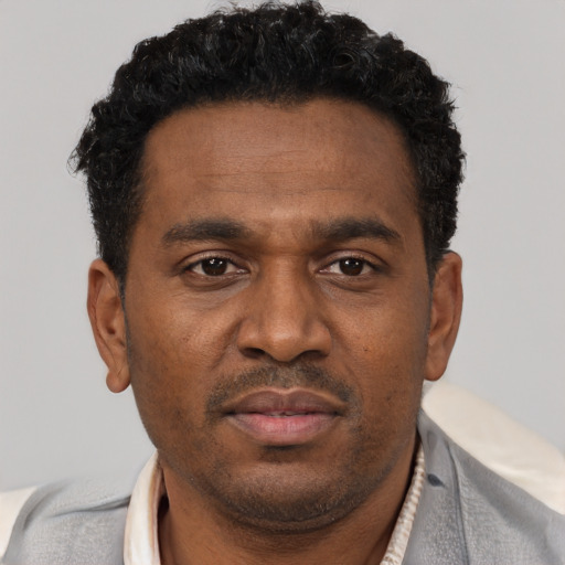 Neutral black adult male with short  black hair and brown eyes