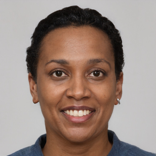 Joyful black adult female with short  black hair and brown eyes