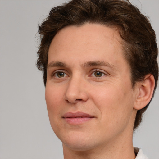 Joyful white adult male with short  brown hair and green eyes