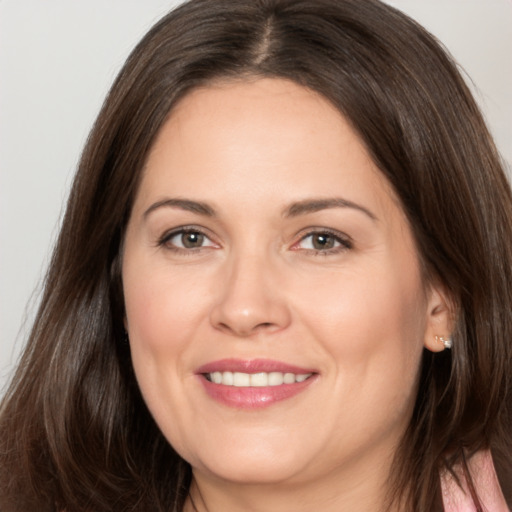 Joyful white adult female with long  brown hair and brown eyes