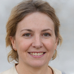 Joyful white adult female with medium  brown hair and grey eyes