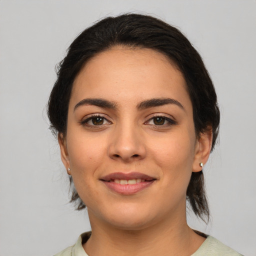 Joyful latino young-adult female with medium  brown hair and brown eyes