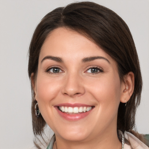 Joyful white young-adult female with medium  brown hair and brown eyes