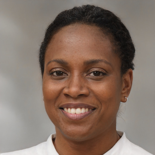Joyful black young-adult female with short  brown hair and brown eyes