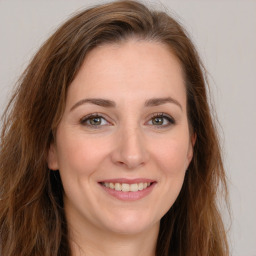 Joyful white young-adult female with long  brown hair and green eyes