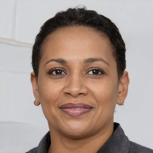 Joyful black adult female with short  brown hair and brown eyes