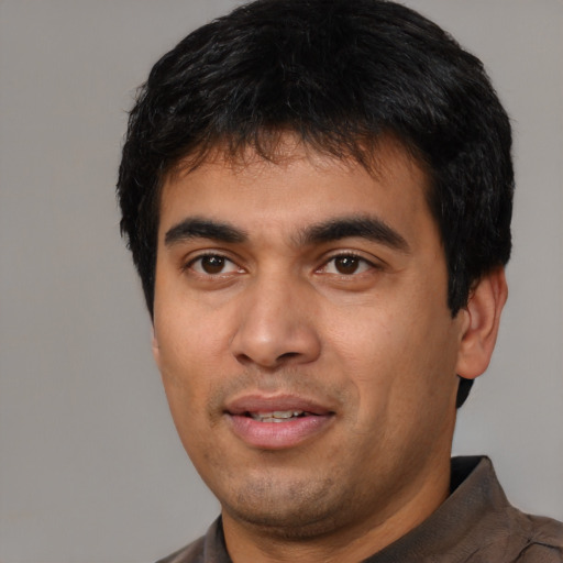 Joyful latino young-adult male with short  black hair and brown eyes