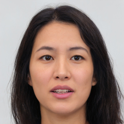 Joyful asian young-adult female with long  brown hair and brown eyes