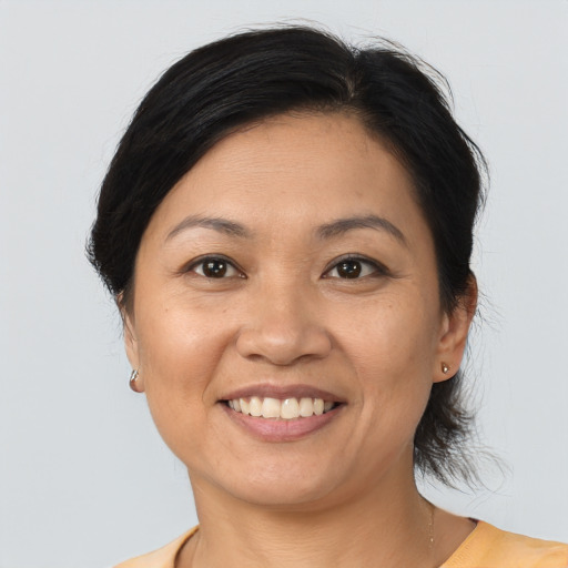 Joyful asian adult female with medium  brown hair and brown eyes