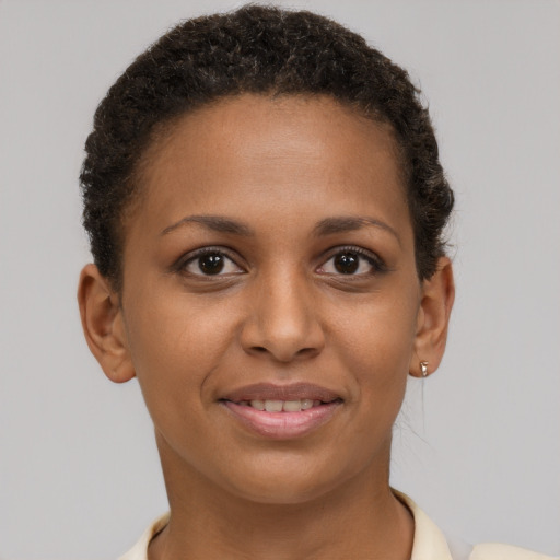 Joyful black young-adult female with short  brown hair and brown eyes