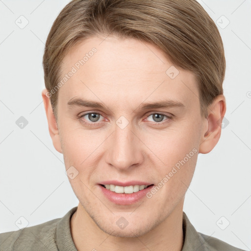 Joyful white young-adult male with short  brown hair and grey eyes