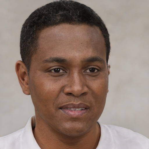 Joyful black young-adult male with short  brown hair and brown eyes