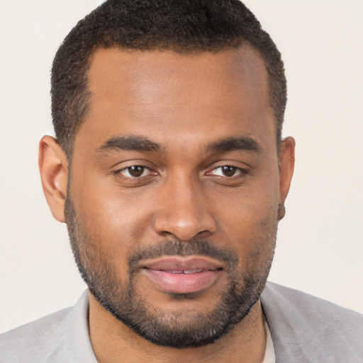 Joyful black young-adult male with short  brown hair and brown eyes