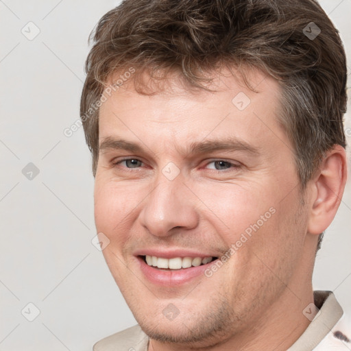 Joyful white adult male with short  brown hair and brown eyes