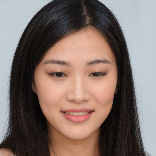 Joyful asian young-adult female with long  brown hair and brown eyes