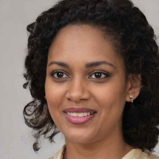 Joyful black young-adult female with medium  brown hair and brown eyes