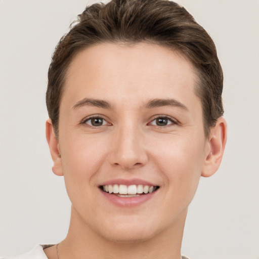 Joyful white young-adult female with short  brown hair and grey eyes