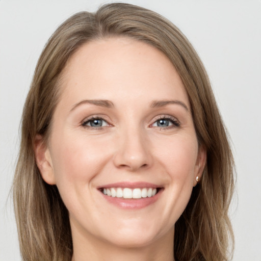 Joyful white young-adult female with long  brown hair and green eyes