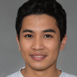 Joyful asian young-adult male with short  black hair and brown eyes