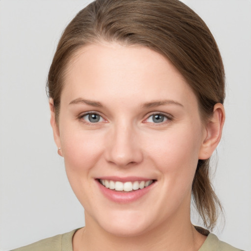 Joyful white young-adult female with medium  brown hair and grey eyes