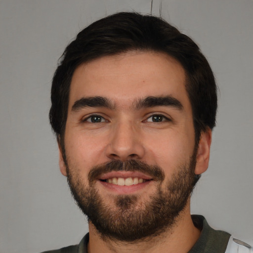 Joyful white young-adult male with short  black hair and brown eyes