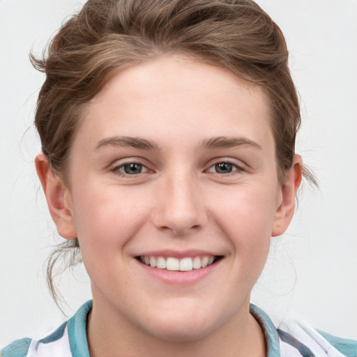 Joyful white young-adult female with short  brown hair and blue eyes